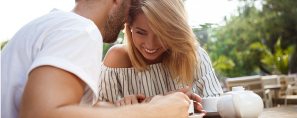 couple qui discute autour d'un café rigolant